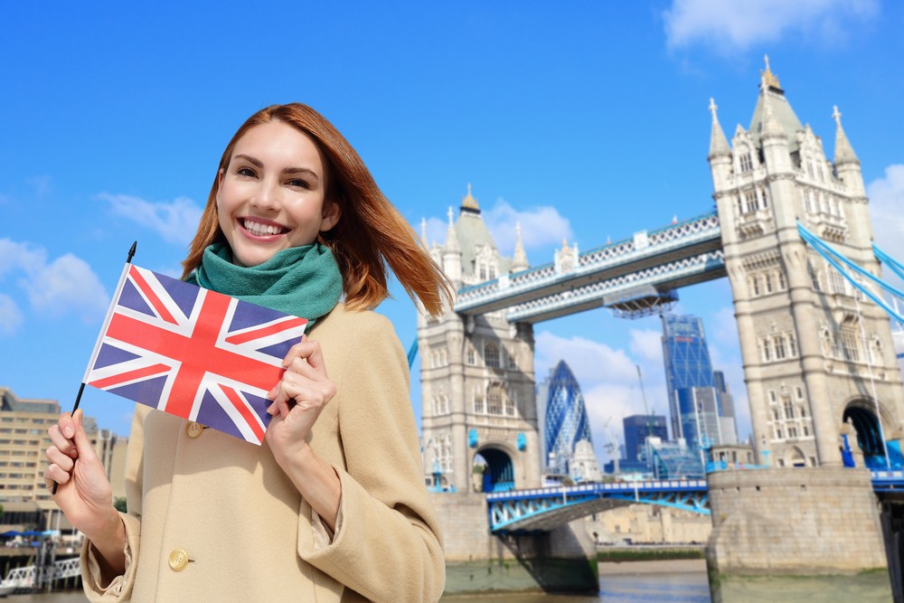 Student with UK flag at Tower Bridge, London